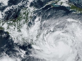 This Saturday, Oct. 8, 2022 satellite image made available by the U.S. National Oceanic and Atmospheric Administration shows Tropical Storm Julia, bottom right, at 4 p.m. EDT. Julia is gaining strength heading westward in the southern Caribbean, and authorities are preparing for a possible hurricane on Colombian islands and in Nicaragua. (NOAA via AP)