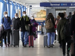 FILE - Travelers walk through Terminal 1 at O'Hare International Airport in Chicago, on Dec. 30, 2021. The websites for some major U.S. airports went down early Monday, Oct. 10, 2022, in an apparent coordinated denial of service incident, although officials said flights were not affected.