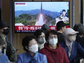 FILE - A TV screen shows a file image of North Korea's missile launch during a news program at the Seoul Railway Station in Seoul, South Korea on Oct. 14, 2022. South Korea says North Korea has fired about 100 shells off its west coast and 150 rounds off its east coast in its latest weapons test Tuesday night, Oct. 18.