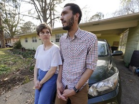 FILE - Lauren Rhoades, 32, left, listens as her husband LaQuenza Morgan, 33, speaks on Feb. 24, 2022 about being checked at a roadblock a short distance from their home in north Jackson, Miss. The two are among several plaintiffs in a lawsuit claiming the Jackson police department is violating people's constitutional rights by using roadblocks to check for driver's licenses and car insurance in majority-Black and low-income neighborhoods. The lawsuit was settled on Wednesday, Oct. 5, 2022, and the city agreed to several changes in how police conduct roadblocks.