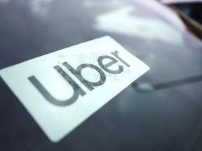 FILE - An Uber sign is displayed inside a car in Palatine, Ill., Thursday, Feb. 10, 2022. The U.S. Department of Labor is proposing a new rule on employee classifications, saying workers have incorrectly been deemed independent contractors, which hurts their rights. The department said Tuesday, Oct. 11, that misclassifying workers as independent contractors instead of employees denies employees' protections under federal labor standards, promotes wage theft, allows certain employers to gain an unfair advantage over businesses, and hurts the economy.