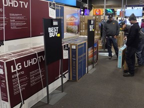 FILE - Customers debate on a television selection at Best Buy, Friday, Nov. 26, 2021, in Indianapolis. The pace of sales at U.S. retailers was unchanged in September 2022 from August as rising prices for rent and food chipped away at money available for other things. Retail sales were flat last month, down from a revised. 0.4% growth in August.