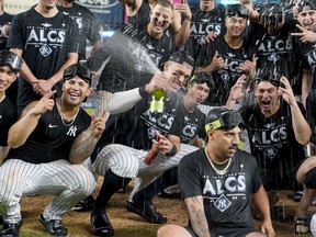 New York Yankees Aaron Judge sprays champagne while celebrating with teammates after the Yankees defeated the Cleveland Guardians in Game 5 of an American League Division baseball series, Tuesday, Oct. 18, 2022, in New York.