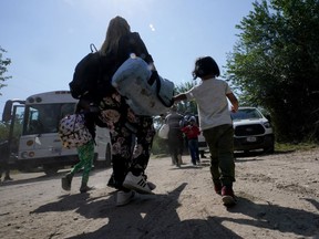 FILE - A migrant family from Venezuela walks to a Border Patrol transport vehicle after they and other migrants crossed the U.S.-Mexico border and turned themselves in, Wednesday, June 16, 2021, in Del Rio, Texas. The Biden administration is developing plans for Venezuelans with financial sponsors to be granted parole to enter the United States, similar to how Ukrainians have been admitted after Russia's invasion, U.S. officials said Tuesday, Oct. 11, 2022.