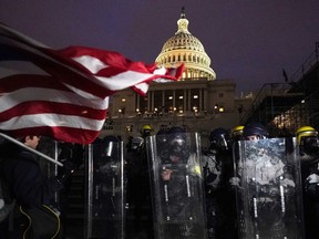 FILE - Police stand guard after a day of riots at the U.S. Capitol in Washington on Wednesday, Jan. 6, 2021. On Friday, Oct. 21, 2022, a Tennessee business owner who scaled a wall outside the U.S. Capitol was sentenced to four years in prison after he was convicted of five charges connected to the raid on Jan. 6, 2021, federal prosecutors said.