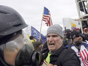 FILE - In this image from video, Alan William Byerly, center, attacks an Associated Press photographer during a riot at the U.S. Capitol in Washington, Jan. 6, 2021. On Sunday, Oct. 9, 2022, federal prosecutors recommended a prison sentence of nearly four years for Byerly, of Pennsylvania, who pleaded guilty to assaulting the AP photographer and using a stun gun against police officers during a mob's attack on the U.S. Capitol.