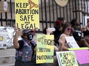 FILE - A small group, including Stephanie Batchelor, left, sits on the steps of the Georgia state Capitol protesting the overturning of Roe v. Wade on June 26, 2022. A trial to determine whether Georgia can continue to ban abortion as early as six weeks into a pregnancy is set to begin in an Atlanta courtroom on Monday, Oct. 24, 2022.