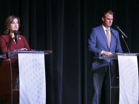Oklahoma Republican Gov. Kevin Stitt, right, listens as his Democratic challenger Joy Hofmeister, the state's public schools superintendent, speaks during a debate at Will Rogers Theatre in Oklahoma City, Wednesday, Oct. 19, 2022.