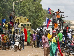 Supporters of Capt. Ibrahim Traore cheer with Russian flags in the streets of Ouagadougou, Burkina Faso, Sunday, Oct. 2, 2022. Burkina Faso's new junta leadership is calling for calm after the French Embassy and other buildings were attacked.