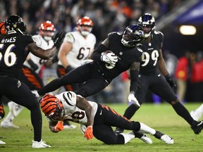 Baltimore Ravens' Patrick Queen, top, is tackled by Cincinnati Bengals' Joe Mixon, bottom, after intercepting a pass during the second half of an NFL football game, Sunday, Oct. 9, 2022, in Baltimore.