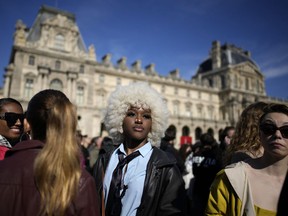 Fashion lovers wait in the courtyard of the Louvre museum during Louis Vuitton ready-to-wear Spring/Summer 2023 fashion collection presented Tuesday, Oct. 4, 2022 in Paris.