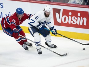 Montreal Canadiens' Juraj Slafkovsky battles for the puck against Toronto Maple Leafs' Jake Muzzin during second period NHL hockey action in Montreal, on Wednesday, Oct. 12, 2022.