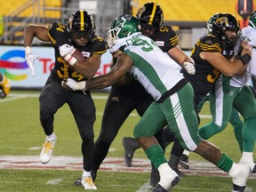 Hamilton Tiger Cats running back Wes Hills (34) runs against the Saskatchewan Roughriders during second half CFL football game action in Hamilton, on Friday, October 7, 2022.&ampnbsp;Hills and defensive end Malik Carney of the Hamilton Tiger-Cats and Winnipeg Blue Bombers receiver Dalton Schoen were named the Canadian Football League's top performer for Week 18 on Wednesday.
