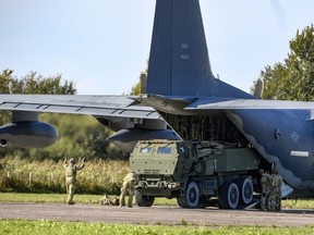 FILE - Soldiers load a High-Mobility Artillery Rocket System (HIMARS ) from a US Special Operations MC-130J aircraft during military exercises at Spilve Airport in Riga, Latvia, on Sept. 26, 2022. A series of embarrassing military losses for Moscow in recent weeks has presented a growing challenge for prominent hosts of Russian news and political talk shows scrambling to find ways to paint Kyiv's gains in a way that is still favorable to the Kremlin.