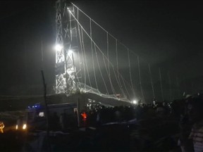 Rescuers work at night after a cable bridge across the Machchu river collapsed in Morbi district, western Gujarat state, India, Sunday, Oct.30, 2022. Dozens are dead and many are feared injured in the accident.