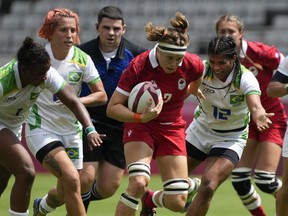 Canada's Karen Paquin, centre, is pursued by Brazil's, from left, Mariana Nicolau, Luiza Campos, and Thalita da Silva Costa, as she runs on her way to scoring a try, in their women's rugby sevens match at the 2020 Summer Olympics, Thursday, July 29, 2021 in Tokyo, Japan. Veteran flanker Paquin and Canada face the U.S. for the second time in a week Saturday at the Rugby World Cup in New Zealand. But this time it's win or go home as the North American rivals meet in the quarterfinal.