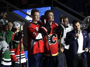 Ottawa Senators' Brady Tkachuk, left, and his brother Calgary Flames' Matthew Tkachuk watch the Skills Competition, part of the NHL All-Star weekend, Friday, Jan. 24, 2020, in St. Louis.