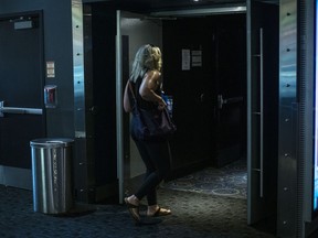 A moviegoer steps into an auditorium at a Cineplex Movie Theatre in Toronto on Friday, July 16, 2021.