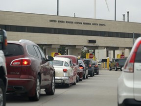In this July 20, 2018 photo, traffic backs up at the border station as motorists leave Manitoba for the United States at Pembina, N.D. Canada's Prairie premiers and two U.S. governors want their respective countries to restore pre-pandemic operating hours at entry points along their shared land border.