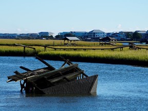 A boat house is overturned in the inlet between Pawleys Island and the mainland following winds and rain from Hurricane Ian on Saturday, Oct. 1, 2022, in Pawleys Island, S.C.