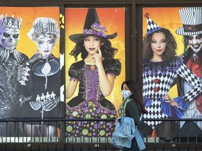 A woman walks past a Halloween shop in Montreal, Thursday, Oct. 15, 2020. Quebec's professional order of nurses is launching a shock campaign this Halloween to encourage Quebecers to ditch their sexy nurse costumes for real uniforms.