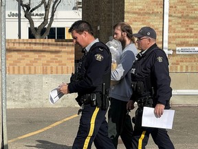 One of the Mounties escorting a Saskatchewan man convicted of hate speech is photographed wearing the "thin blue line" patch on his uniform. The symbol of police solidarity has been co-opted by white nationalists. The Canadian Press