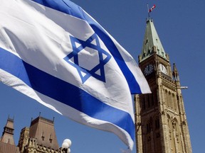 The Israeli flag flies with the Peace Tower in the background on Parliament Hill in Ottawa on April 21, 2002. The Israeli Embassy in Ottawa says it feels at risk of violence after nearly three years of pushing Global Affairs Canada to increase its security.