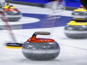 Players sweep a rock at the Tim Hortons Brier in Lethbridge, Alta. on March 6, 2022. Just 16 of 56 U Sports schools have varsity curling teams. Of the 98 schools in the Canadian Collegiate Athletic Association, there are just 14 men's curling teams and a dozen women's teams this season.