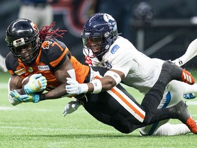 BC Lions' Lucky Whitehead (left) catches a pass and gets tackled by Toronto Argonauts' DaShaun Amos during second half of CFL football action in Vancouver on June 25, 2022. Toronto (8-6) hosts B.C. (10-4) on Friday night at BMO Field.
