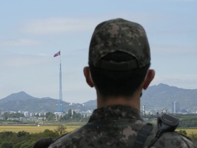 A North Korean flag flutters in the wind as a South Korean army soldier stands guard at the border villages of Panmunjom in Paju, South Korea, Tuesday, Oct. 4, 2022. North Korea on Tuesday fired an intermediate-range ballistic missile over Japan for the first time in five years, forcing Japan to issue evacuation notices and suspend trains during the flight of the weapon that is capable of reaching the U.S. territory of Guam.