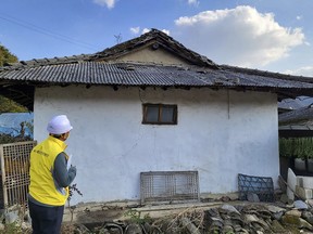 An official from Goesan county checks a house after an earthquake hit the area in Goesan, South Korea, Saturday, Oct. 29, 2022. The earthquake shook a small agricultural county in South Korea's central region on Saturday, but officials said there were no immediate reports of damage.