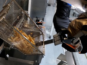 The Flippy 2 robot takes fries out of a vat of oil at a lab of manufacturer Miso Robotics Inc in Pasadena, California.
