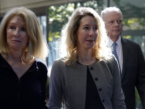 FILE - Former Theranos CEO Elizabeth Holmes, center, her mother, Noel Holmes, left, and father, Christian Holmes IV, arrive at federal court in San Jose, Calif., on Sept. 1, 2022. On Monday, Oct. 17, disgraced Theranos CEO Holmes will play one of her last cards to avoid a prison sentence when a federal judge questions a key prosecution witness who expressed post-trial regrets about testimony that helped convince a jury to convict her for investor fraud.