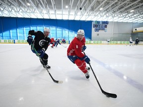 Vancouver Canucks' Brock Boeser, right, tries to keep the puck away from Oliver Ekman-Larsson, of Sweden, during the NHL hockey team's training camp in Whistler, B.C., Thursday, Sept. 22, 2022.