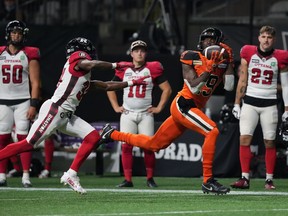 B.C. Lions' Dominique Rhymes, right, makes the reception as Ottawa Redblacks' Brandin Dandridge defends during the first half of CFL football game in Vancouver, on Friday, September 30, 2022.