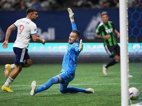 Vancouver Whitecaps' Lucas Cavallini (9) scores against Austin FC goalkeeper Brad Stuver during the second half of an MLS soccer game in Vancouver, on Saturday, October 1, 2022.