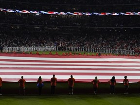 The American flag is unfurled during the national anthem beforeGame 1 of baseball's World Series between the Houston Astros and the Philadelphia Phillies on Friday, Oct. 28, 2022, in Houston.