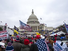 FILE - Rioters loyal to President Donald Trump rally at the U.S. Capitol in Washington on Jan. 6, 2021. A new poll shows that many Americans remain pessimistic about the state of their democracy and the way elected officials are chosen. The results of the Associated Press-NORC Center for Public Affairs Research survey come nearly two years after a divisive presidential election spurred false claims of widespread fraud and a violent attack on the U.S. Capitol.