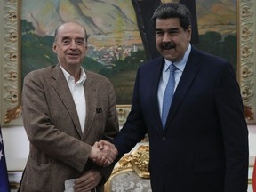 Colombia's Foreign Minister Alvaro Leyva, left, shake hands with Venezuela's President Nicolas Maduro during a meeting at Miraflores Presidential Palace in Caracas, Venezuela, Tuesday, Oct. 4, 2022.