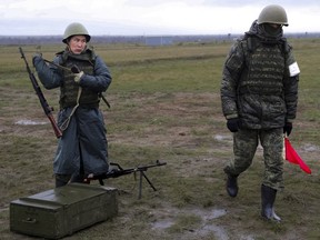 A recruit takes his weapons following an instructor during a military training at a firing range in Volgograd region, Russia, Thursday, Oct. 27, 2022. (AP Photo)