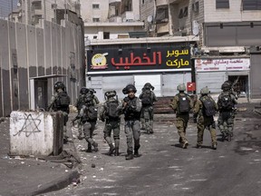 Israeli security forces patrol in Shuafat refugee camp in Jerusalem, Monday, Oct. 10, 2022. A manhunt follows a Saturday shooting attack at a military checkpoint in east Jerusalem where a Palestinian gunman fled from the scene after he opened fire, killing a female Israeli soldier and wounding three others, one of them seriously.