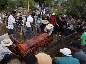 Residents bury Wilmer Rojas the day after he was killed in a mass shooting in San Miguel Totolapan, Mexico, Thursday, Oct. 6, 2022. A drug gang bursted into the town hall and shot to death 20 people, including a mayor and his father, officials said Thursday.
