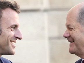 French President Emmanuel Macron, left, welcomes German Chancellor Olaf Scholz at the Elysee Palace in Paris, Wednesday, Oct. 26, 2022. French President Emmanuel Macron is scheduled to meet in Paris with German Chancellor Olaf Scholz amid divergences between the two neighbors and key European Union allies over EU strategy, defense and economic policies.