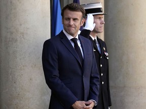 French President Emmanuel Macron greets journalists as he arrives to welcome German Chancellor Olaf Scholz, unseen, at the Elysee Palace in Paris, Wednesday, Oct. 26, 2022. French President Emmanuel Macron is scheduled to meet in Paris with German Chancellor Olaf Scholz amid divergences between the two neighbors and key European Union allies over EU strategy, defense and economic policies.