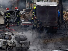 Fire and rescue workers attend a building hit by a missile in central Kyiv
