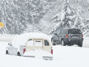 Vehicles make their way along the snow-covered highway in Victoria, B.C., Tuesday, Feb. 12, 2019.