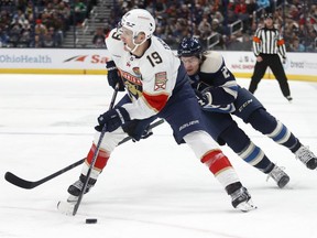 Florida Panthers forward Matthew Tkachuk, left, controls the puck in front of Columbus Blue Jackets defenceman Andrew Peeke during the first period an NHL hockey game in Columbus, Ohio, Sunday, Nov. 20, 2022.