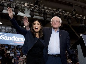 Democratic presidential candidate Sen. Bernie Sanders, I-Vt., accompanied by Rep. Alexandria Ocasio-Cortez, D-N.Y., left, takes the stage at campaign stop at the Whittemore Center Arena at the University of New Hampshire in Durham, N.H., on Feb. 10, 2020.