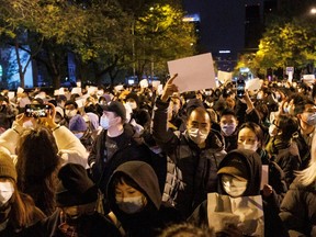 People hold white sheets of paper in protest of coronavirus disease (COVID-19) restrictions, after a vigil for the victims of a fire in Urumqi, as outbreaks of the coronavirus disease continue in Beijing, China, November 27, 2022.