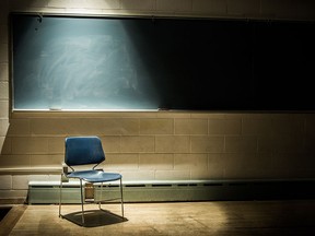 An empty chair in front of a blackboard.
